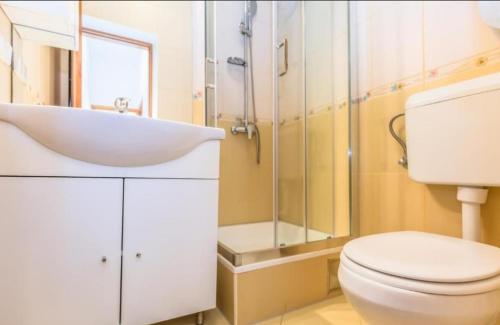 a bathroom with a white toilet and a sink at Luxury apartment Roko in Omiš