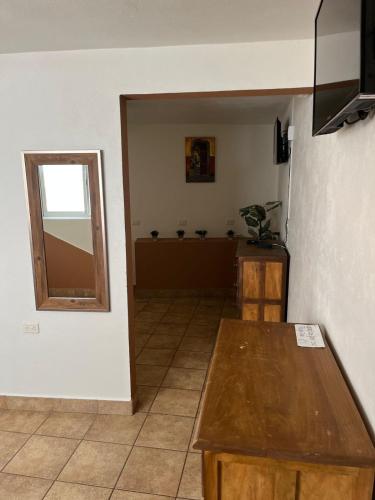 a living room with a table and a mirror at Hotel Jardín del Cantador in Guanajuato
