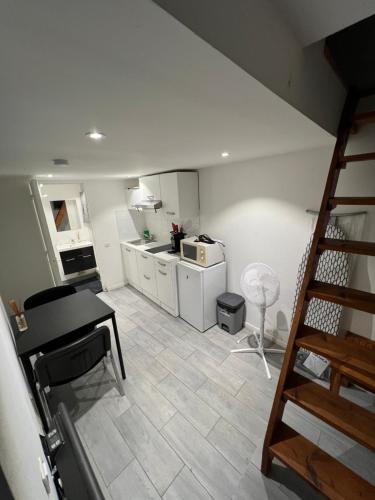 une cuisine avec un escalier menant à une cuisine avec un comptoir dans l'établissement Studio indépendant plein pied avec mezzanine, à Joinville-le-Pont