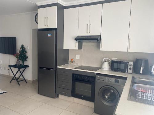 a kitchen with a refrigerator and a washing machine at Leisure apartment in Ballito