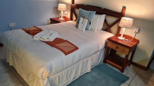 1 dormitorio con 1 cama blanca grande y 2 lámparas en maya bnb, en Nata