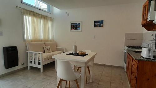 cocina con mesa blanca y sillas en una habitación en Belgrano 238 en Capilla del Monte
