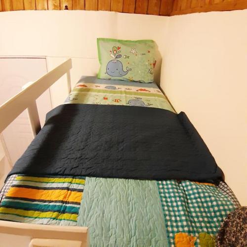 a bedroom with a bed with a quilt on it at BLUE HOUSE OCEAN VIEW in Santa Bárbara de Samaná