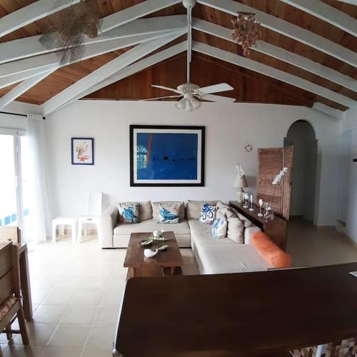a living room with a couch and a ceiling fan at BLUE HOUSE OCEAN VIEW in Santa Bárbara de Samaná