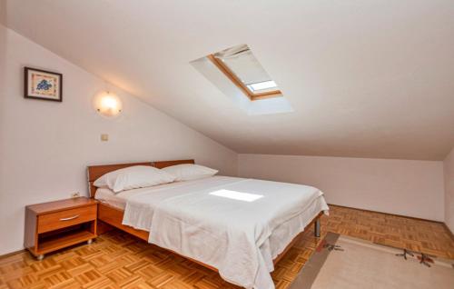 a bedroom with a bed and a skylight at Apartman Mira in Makarska