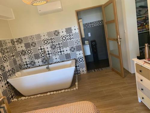 bagno con vasca bianca e specchio di VILLA U TEMPIU CORSU a Patrimonio