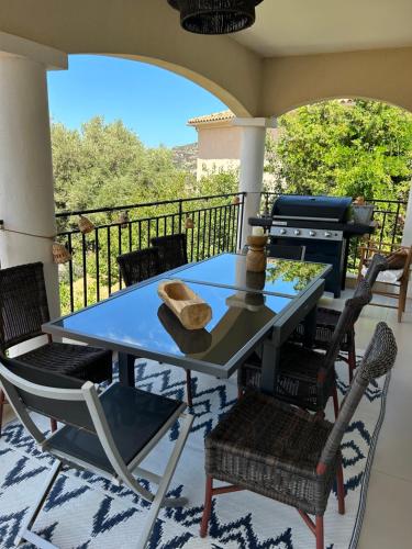 d'une table et de chaises sur un balcon avec barbecue. dans l'établissement VILLA U TEMPIU CORSU, à Patrimonio