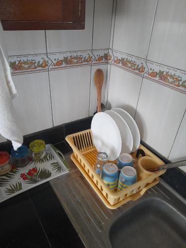a kitchen sink with a dish drying rack and dishes at Galene Abode Studio Apartment, Nyali in Mombasa