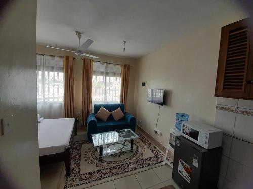Habitación pequeña con sofá azul y cama en Galene Abode Studio Apartment, Nyali, en Mombasa