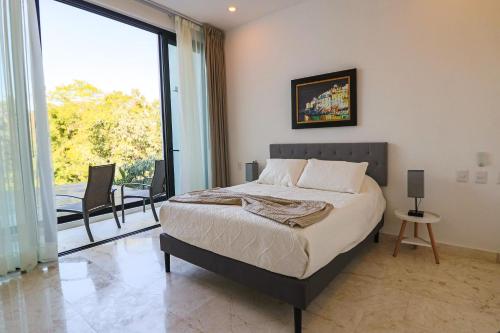 1 dormitorio con cama y ventana grande en Hermosa Villa en Tulum Country Club acceso a playa en Akumal