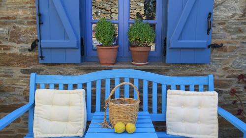 a blue bench in front of a window with plants at Saint Louis in Andros