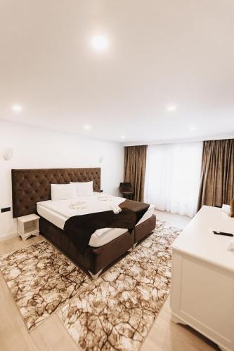 a bedroom with a large bed and a rug at Royal Alpin Crown in Cavnic