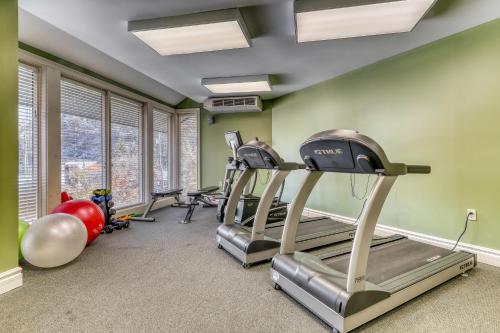 un gimnasio con cinta de correr y equipamiento de ejercicio en una sala con paredes verdes en Baskins Creek Condos en Gatlinburg