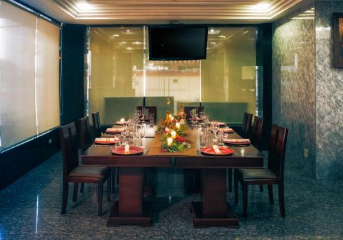 a long table with chairs and a christmas tree on it at Airport Hotel Guayaquil in Guayaquil