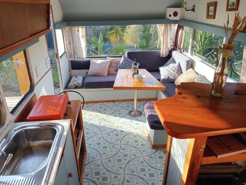 an rv living room with a couch and a table at Down to earth NZ in Kerikeri