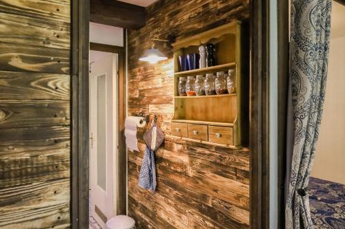a bathroom with a wooden wall with a shelf on it at Geographer´s Suite in Siegsdorf