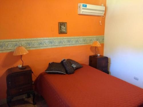 1 dormitorio con 1 cama roja con 2 lámparas y ventilador en Casa de Campo Mama Lucia en 