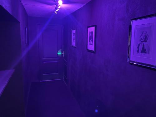 fioletowy pokój z korytarzem z fioletowymi światłami w obiekcie Cinema Paradiso - Appartement de charme avec Sauna, Hammam, spa w mieście Issoudun