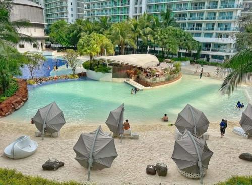 a swimming pool with umbrellas and people in the water at SM Bicutan Affordable Rooms in Manila
