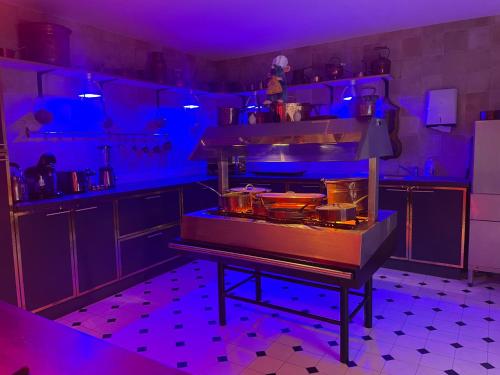 une cuisine avec des lumières violettes dans l'établissement Cinema Paradiso - Appartement de charme avec Sauna, Hammam, spa, à Issoudun