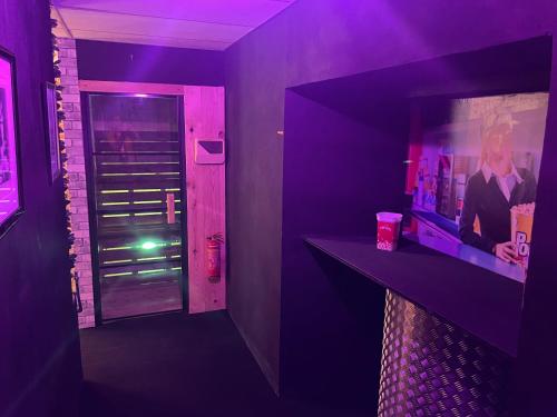 a purple room with a bar and a door at Cinema Paradiso - Appartement de charme avec Sauna, Hammam, spa in Issoudun