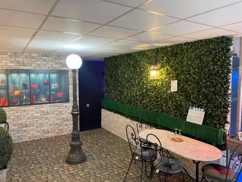 a room with a green wall with a table and chairs at Cinema Paradiso - Appartement de charme avec Sauna, Hammam, spa in Issoudun