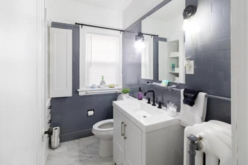 a bathroom with a white sink and a toilet at Stylish 3-bd Haven in Trendy Cleveland Heights! in Cleveland Heights