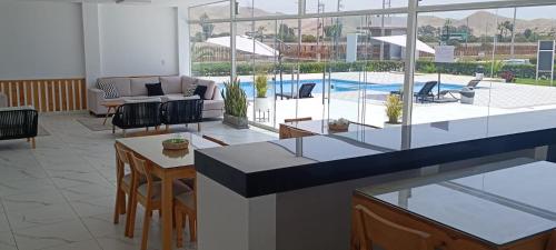 uma cozinha e sala de estar com vista para uma piscina em Departamentos de playa em Cerro Azul
