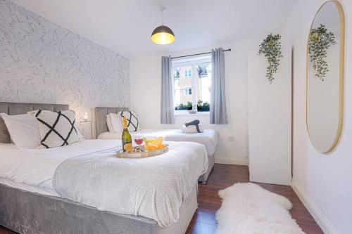 a bedroom with two beds and a tray of fruit on a table at Beautiful Apartment - Close to City Centre - Free Parking, Fast Wifi, SmartTV with Sky TV and Netflix by Yoko Property in Northampton