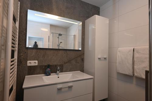 een badkamer met een wastafel en een spiegel bij Spaanse Galeien 79 Cadzand in Cadzand