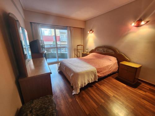 - une chambre avec un lit et une grande fenêtre dans l'établissement Departamento 3 ambientes a una cuadra de la playa - La Perla, à Mar del Plata