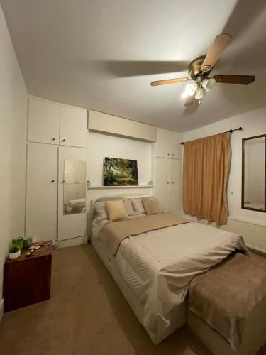 a bedroom with a bed and a ceiling fan at COZY ROOMS 25 min LIVERPOOL STREET in London