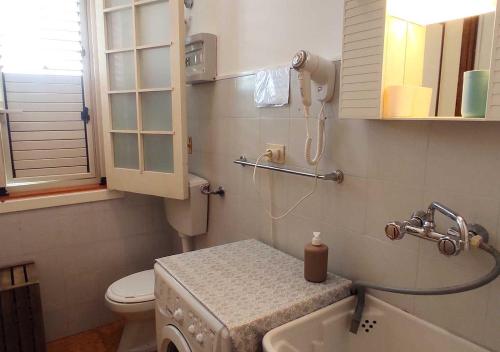 bagno con lavandino, servizi igienici e telefono di Oroblu. Villetta singola a 50 metri dal mare a Marina di Ragusa