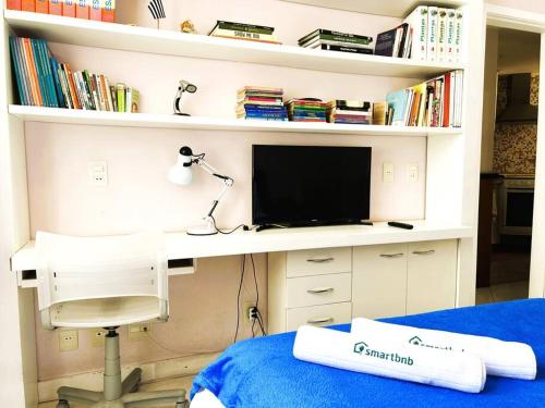 a bedroom with a desk with a tv and a chair at Charme do Leme in Rio de Janeiro