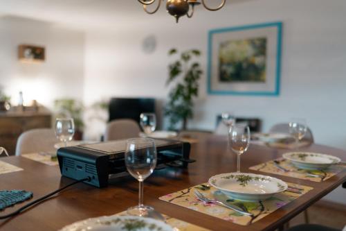 a table with wine glasses and plates on it at Large Apartment 8beds great for family and friends, Mountain View in Amden