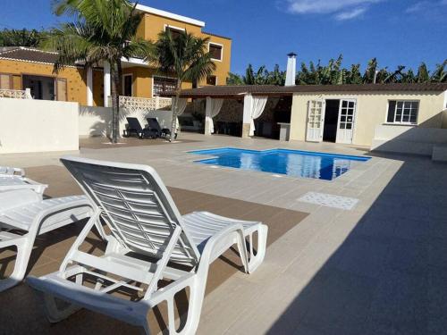 un par de sillas de jardín sentadas junto a una piscina en Casa Costa Molina en Puntallana