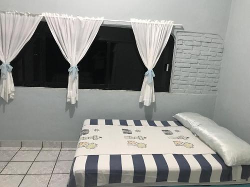 uma cama num quarto com uma janela com cortinas em Ixtapa Playa Linda Hostel em Barrio Nuevo
