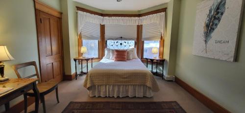 a bedroom with a bed and a desk and a window at Bross Hotel B & B in Paonia