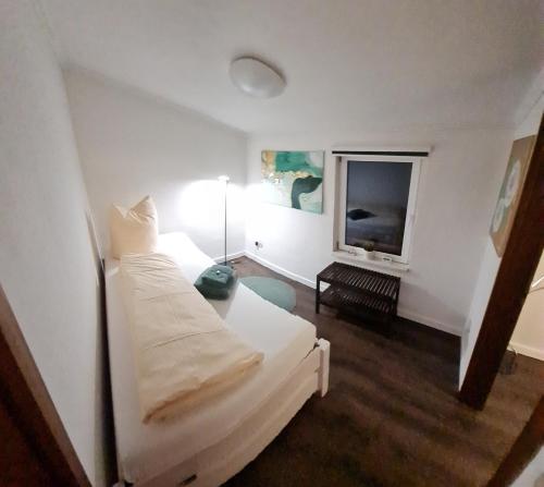 a white room with a bed and a tv at Ferienhaus Grüner Bungalow Kontaktloser CheckIn in Stendell
