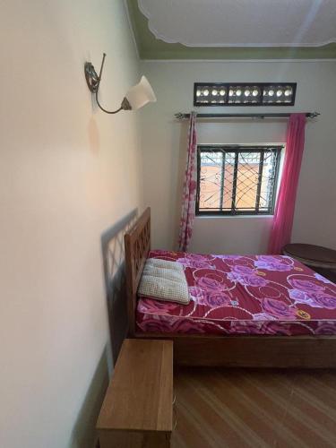 a bedroom with a bed and a window at Lido Azzurro Garuga in Wakiso