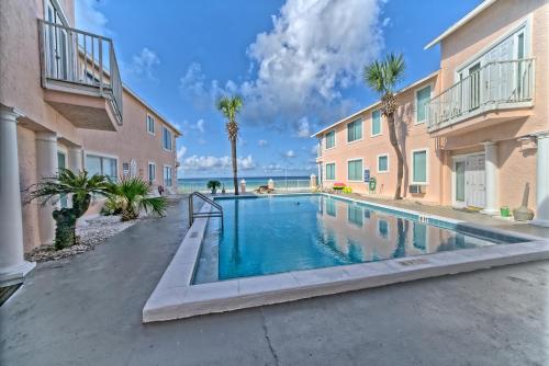 a swimming pool in the courtyard of a building with palm trees at Pineapple Villas in Panama City Beach