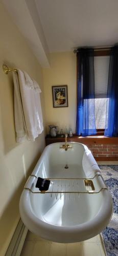 a white bath tub in a room with a window at Bross Hotel B & B in Paonia