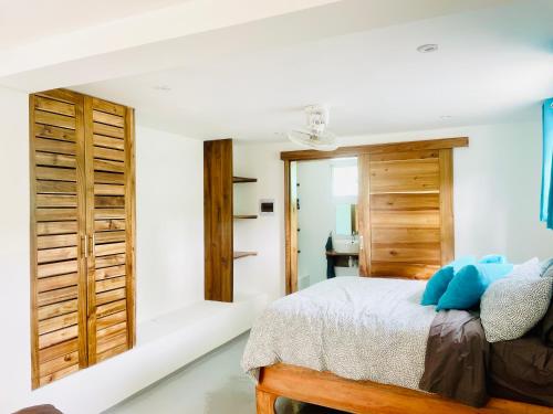 a bedroom with white walls and a bed with blue pillows at Cozy Studio in Private Villa in Las Terrenas