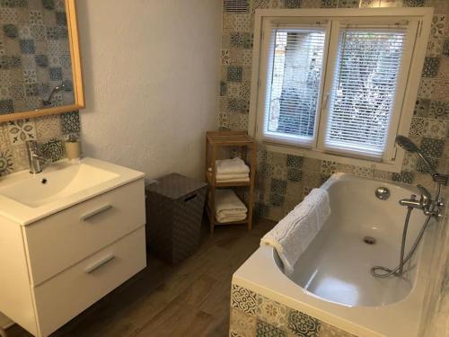 une salle de bain avec une baignoire blanche et un lavabo dans l'établissement Appartement 2/3 pièces (55m²) au cœur du Vexin, à Chars
