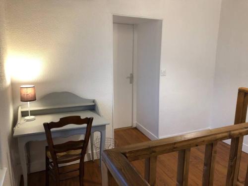 a room with a desk with a lamp and a chair at Appartement 2/3 pièces (55m²) au cœur du Vexin in Chars