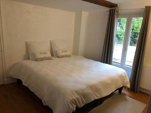 a bedroom with a large white bed with two pillows at Appartement 2/3 pièces (55m²) au cœur du Vexin in Chars