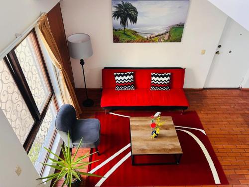 a living room with a red couch and a table at Duplex en primer piso - A media Cuadra Embajada USA in Lima