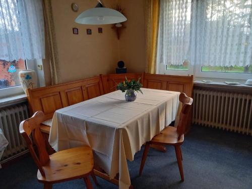 - une table à manger avec un vase de fleurs dans l'établissement Ferienhaus Dobbenland, à Krummhörn