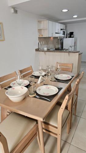 drewniany stół z płytami i miskami w kuchni w obiekcie Complejo Hunter Plottier - Neuquén w mieście Plottier