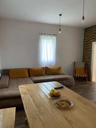 ein Wohnzimmer mit einem Sofa und einem Tisch in der Unterkunft Kuca na kraju sela in Valjevo